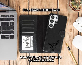 May include: Black full-grain leather phone case with a wallet design. The case features a wolf silhouette and the name "IAN" engraved on the front. The case is open, revealing card slots and an RFID protection card. Text on the case reads "FULL GRAIN LEATHER CASE".