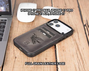 May include: A gray leather iPhone case with a hummingbird design and the initials "MRO". The case has a cardholder and a black frame. The text "FULL GRAIN LEATHER CASE" is at the bottom. The case is next to a laptop and a white mouse.