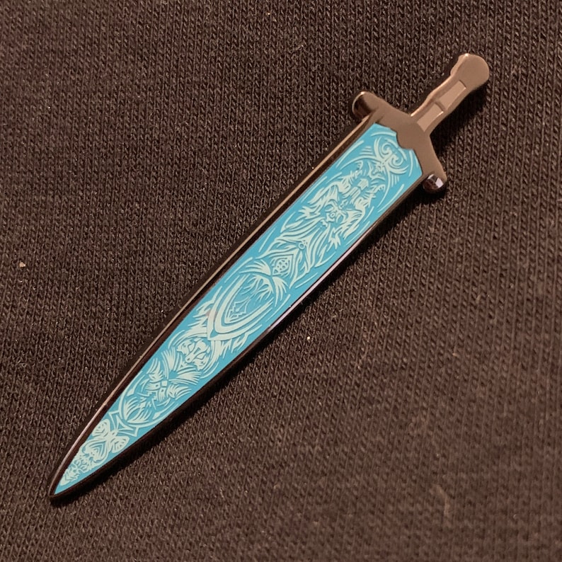 May include: A black metal sword with a blue and white design. The sword has a sharp point and a curved handle.
