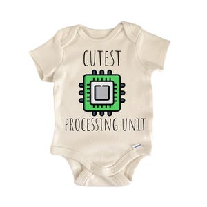 May include: A cream-colored baby onesie with the words "CUTEST PROCESSING UNIT" printed in black. A green and black computer chip graphic is centered above the text. The onesie has short sleeves and a snap closure.