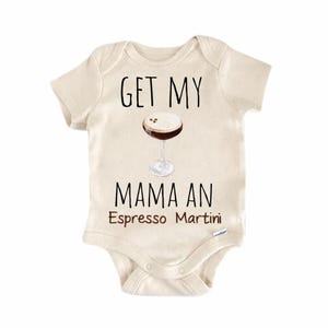 Op de afbeelding: Crèmekleurige babyromper met de tekst "GET MY MAMA AN Espresso Martini" in zwart en bruin. Een afbeelding van een espresso martini staat boven de tekst. De romper heeft korte mouwen en een drukknoopsluiting.