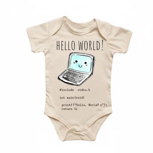 Puede incluir: Body de bebé color crema con el texto "HELLO WORLD!" sobre un gráfico de portátil sonriente. Debajo, se muestra código que incluye "#include stdio.h" y "printf("Hello, World!
");".