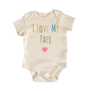 Może przedstawiać: Kremowe body niemowlęce z napisem "I LOVE MY PAPI" w kolorowych literach i różowym sercem. Body z krótkim rękawem ma zatrzaski na dole i jest wykonane z miękkiej tkaniny.