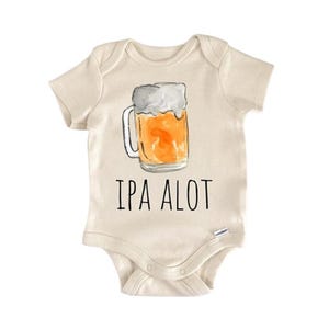 Puede incluir: Body de bebé color crema con una ilustración de una jarra de cerveza con líquido ámbar y espuma blanca. El texto "IPA ALOT" está impreso en negro. Un divertido atuendo para bebés.