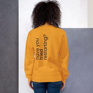 Può includere: Una tazza di ceramica bianca con manico nero e la scritta "But First, Coffee" in grassetto nero. La tazza è appoggiata su una superficie di legno. La tazza è alta circa 10 cm.