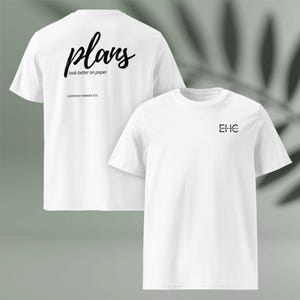 May include: Two white t-shirts. One shirt has the word "plans" in a cursive font on the back, with the text "look better on paper" below it. The other shirt has the letters "EHC" on the front. The shirts are from "EVERYDAY HEROES CO."