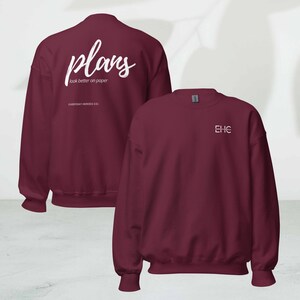 May include: Maroon sweatshirt with white text on the back that reads "plans look better on paper" and the brand name "EVERYDAY HEROES CO." The front of the sweatshirt has the initials "EHC" in white. The sweatshirt is a solid color.