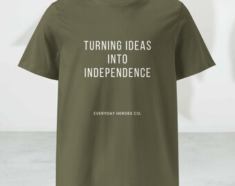 May include: Olive green t-shirt with the text "TURNING IDEAS INTO INDEPENDENCE" in white block letters. The brand name "EVERYDAY HEROES CO." is printed below the text. The shirt has short sleeves and a crew neck.