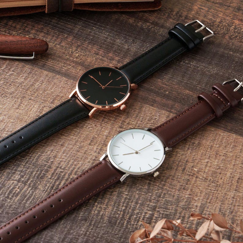 a couple of watches sitting on top of a wooden table