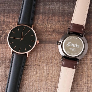 a couple of watches sitting on top of a wooden table