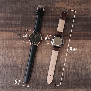 a couple of watches sitting on top of a wooden table