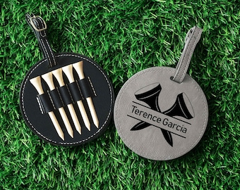 May include: Two golf-themed round tags on a green surface. One black tag holds wooden golf tees. The other gray tag features a golf tee graphic and the name "Terence Garcia". Both tags have a strap.