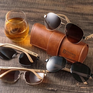 a pair of sunglasses and a leather case sitting on a table