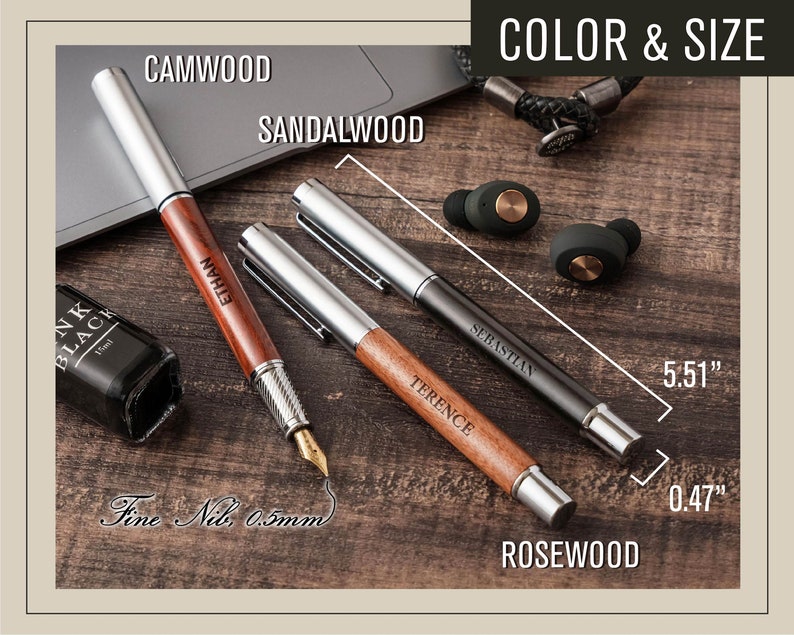 a wooden table topped with a laptop computer and a pen