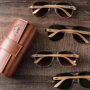 three pairs of sunglasses and a case sitting on a table