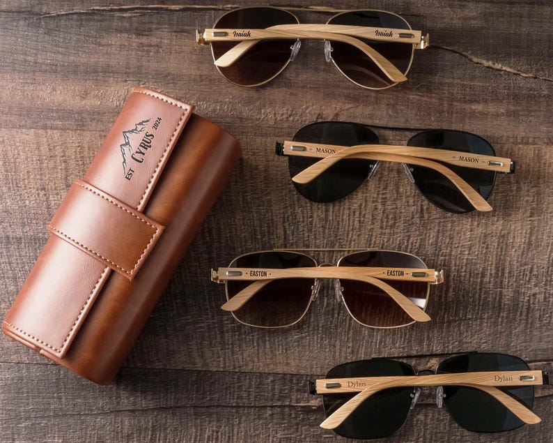 three pairs of sunglasses and a case sitting on a table