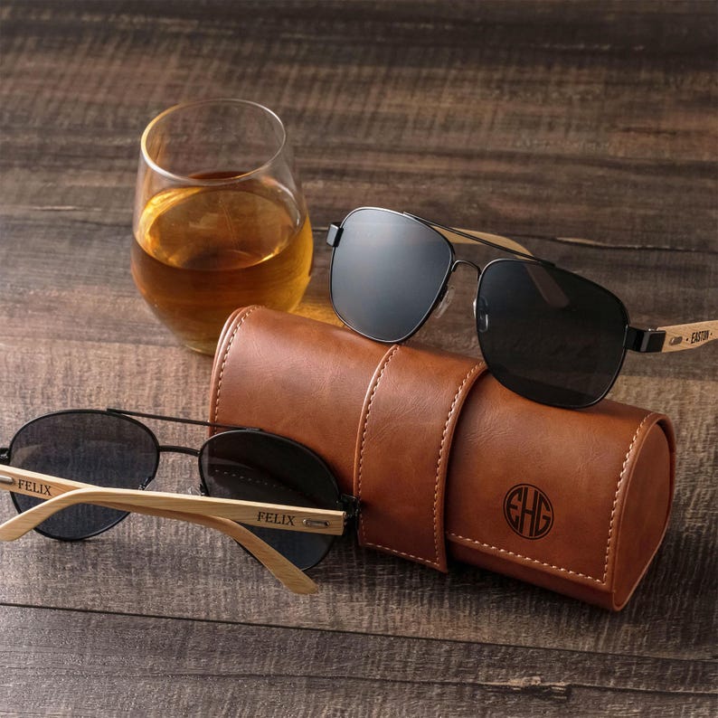 three pairs of sunglasses sitting on top of a wooden table