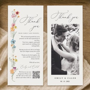 Op de afbeelding: Twee bedankkaarten voor een bruiloft op een houten dienblad. Eén kaart heeft kleurrijke bloemaccenten en de tekst "Thank you". De andere kaart heeft een zwart-witfoto van een stel en de tekst "Thank you."