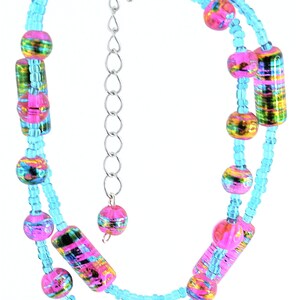 May include: A double-strand bracelet with a silver clasp. The bracelet features colorful glass beads in shades of pink, blue, and green.