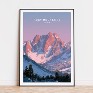 May include: A framed print featuring the Ruby Mountains in Nevada. The artwork depicts a mountain range with snow-capped peaks illuminated by the warm light of a sunrise or sunset. The sky transitions from a soft blue to a pink hue.