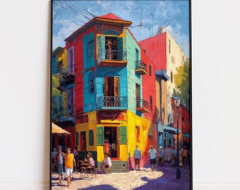 May include: A framed art print of a colorful street scene. The buildings are painted in vibrant hues of red, blue, yellow, and orange. People are walking on the street. The artwork is displayed in a black frame.