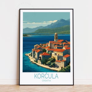 May include: A framed art print of Korcula, Croatia. The image depicts a coastal town with red-tiled roofs, stone buildings, and a tall bell tower. The sea is a deep blue, and mountains are in the background. The text "KORCULA CROATIA" is at the bottom.