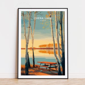 May include: A framed art print featuring a serene landscape of Chena Lake, Alaska. The artwork depicts a lakeside scene with birch trees, a picnic table, and a vibrant sunset. The text "CHENA LAKE ALASKA" is displayed at the top.