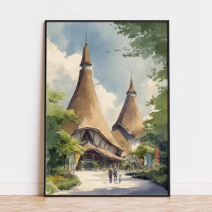 May include: Watercolor print of a building with two tall, conical towers and a covered entrance. The artwork features a muted color palette with shades of brown, green, and blue, and is framed in black. A family walks along a path in front of the building.