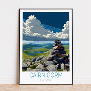 Könnte beinhalten: Ein gerahmter Kunstdruck von Cairn Gorm, Schottland, mit einem aufgeschichteten Steinhaufen im Vordergrund. Die Landschaft umfasst grüne Hügel, blaue Seen und einen dramatischen Himmel mit weißen Wolken und einem tiefblauen Hintergrund. Der Text "CAIRN GORM SCOTLAND" befindet sich unten.