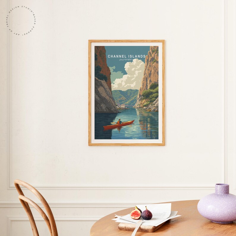 K&ouml;nnte beinhalten: Ein gerahmter Kunstdruck mit einem Vintage-Reiseposter-Design. Das Poster zeigt eine malerische Ansicht der Kanalinseln mit einem Kajakfahrer auf dem Wasser. Der Text "CHANNEL ISLANDS" ist oben zu sehen.