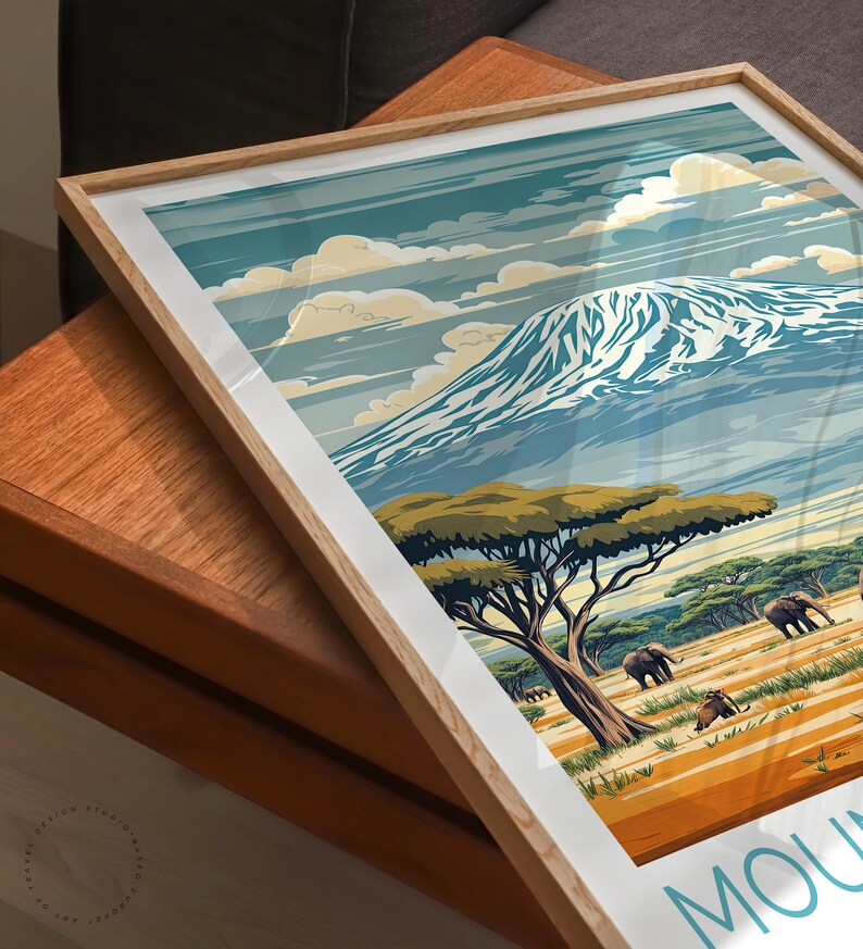 May include: A framed print of a mountain landscape with a snowy peak, green trees, and elephants in the foreground. The print has a vintage travel poster style with the text "Mount" at the bottom.