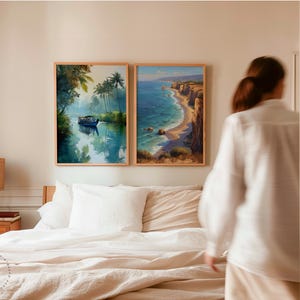 Puede incluir: Dos impresiones art&iacute;sticas enmarcadas de paisajes. Una representa un barco en un r&iacute;o tranquilo con exuberante vegetaci&oacute;n y palmeras. La otra muestra una escena costera con acantilados, una playa y olas del mar. Ambas est&aacute;n en marcos de madera.