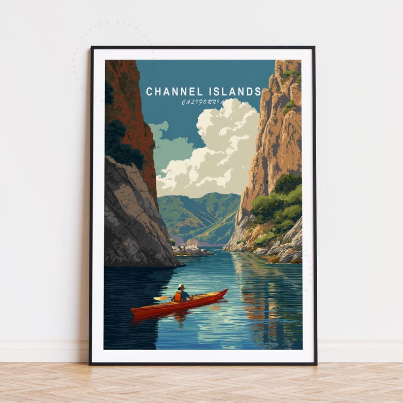 K&ouml;nnte beinhalten: Ein gerahmter Kunstdruck mit einer malerischen Ansicht der Channel Islands in Kalifornien. Das Kunstwerk zeigt einen Kajakfahrer in einem roten Kajak auf ruhigem blauem Wasser, umgeben von hoch aufragenden Klippen und &uuml;ppigen gr&uuml;nen H&uuml;geln unter einem teilweise bew&ouml;lkten Himmel. Der Text "CHANNEL ISLANDS CALIFORNIA" steht oben.