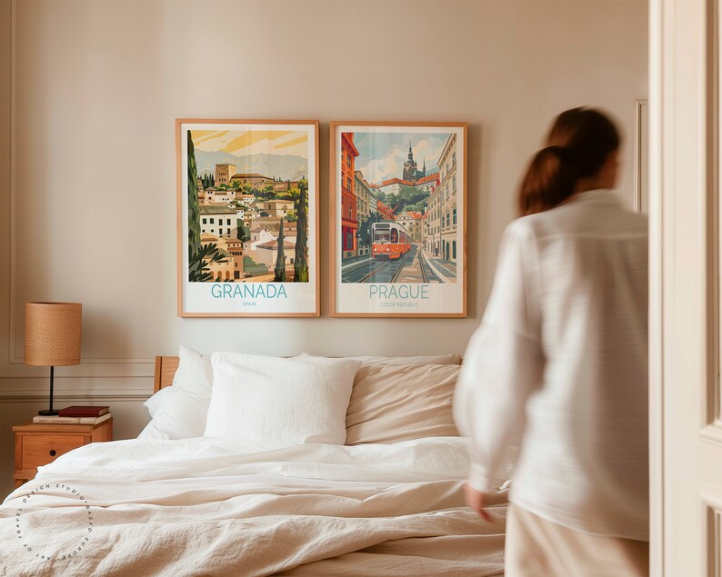 Puede incluir: Dos p&oacute;sters de viaje enmarcados, uno que representa Granada, Espa&ntilde;a, y el otro Praga, Rep&uacute;blica Checa, cuelgan en una pared de color beige claro sobre una cama blanca con un edred&oacute;n de lino beige y almohadas blancas.