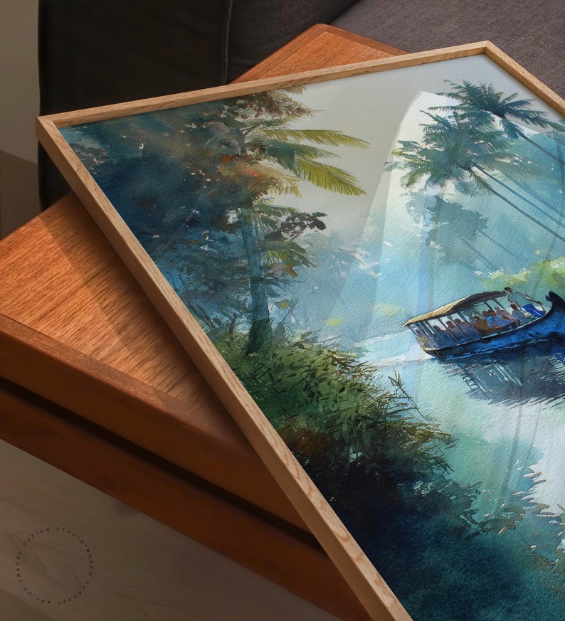 Puede incluir: Pintura a la acuarela de una escena de r&iacute;o tropical con un barco que transporta pasajeros. La obra de arte est&aacute; enmarcada en un marco de madera clara. La pintura presenta exuberante follaje verde, palmeras y un barco azul en el agua.