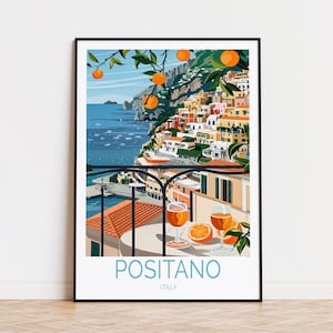 May include: A colorful illustration of Positano, Italy, with a view of the town from a balcony overlooking the Mediterranean Sea. The illustration features a glass of orange juice and a slice of orange on a table, with a lush orange tree in the foreground.