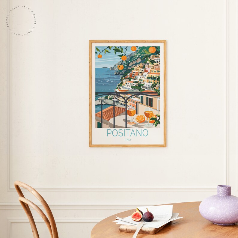 May include: A colorful illustration of Positano, Italy, with a view of the town from a balcony overlooking the Mediterranean Sea. The illustration features a glass of orange juice and oranges on the balcony.