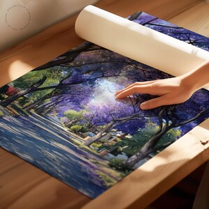 Peut inclure: Une impression d'art enroul&eacute;e repr&eacute;sentant une rue bord&eacute;e d'arbres &agrave; fleurs mauves. L'impression est partiellement d&eacute;roul&eacute;e, r&eacute;v&eacute;lant une illustration d&eacute;taill&eacute;e d'une journ&eacute;e ensoleill&eacute;e dans une rue r&eacute;sidentielle. La palette de couleurs comprend des nuances de violet, de vert et de bleu.