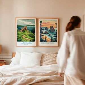 K&ouml;nnte beinhalten: Zwei gerahmte Landschaftsdrucke h&auml;ngen an einer Wand &uuml;ber einem Bett mit wei&szlig;en Bettw&auml;sche. Der Druck links zeigt eine gr&uuml;ne Landschaft mit einem Schloss und dem Text "Loch Ness, Schottland". Der Druck rechts zeigt eine Strandszene mit dem Text "Oregon Coast".