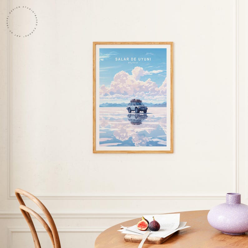 May include: A framed poster with a blue car driving on a white salt flat with a reflection of the car and clouds in the water. The poster has the text "Salar de Uyuni, Bolivia" at the top.