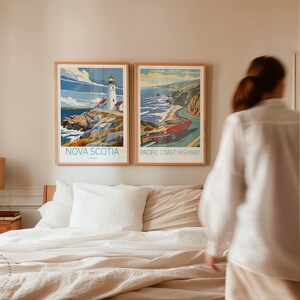 May include: Two framed travel posters hanging on a wall above a bed. The poster on the left shows a lighthouse on a rocky coast with the text "NOVA SCOTIA, Canada". The poster on the right shows a red car driving along a winding road with the text "PACIFIC COAST HIGHWAY".
