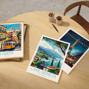 May include: Three framed travel posters on a wooden table. The posters feature illustrations of Lisbon, Portugal, Lake Geneva, Switzerland, and a night scene with a tower in the distance. The posters are in a modern, colorful style.
