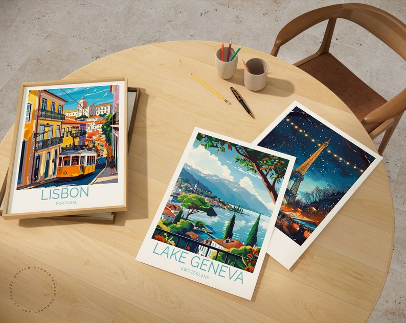 May include: Three framed travel posters on a wooden table. The posters feature illustrations of Lisbon, Portugal, Lake Geneva, Switzerland, and a night scene with a tower in the distance. The posters are in a modern, colorful style.