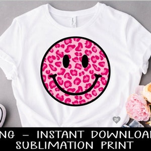 May include: A white t-shirt with a pink and black leopard print smiley face design.  The design is a sublimation print.