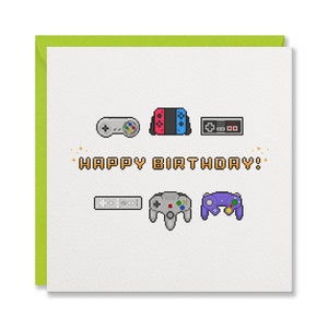 May include: A white birthday card with a green border, decorated with pixel art game controllers. The words "HAPPY BIRTHDAY!" are written in pixelated style. Ideal for a gamer's birthday.