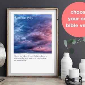 Könnte beinhalten: Gerahmter Druck mit einem lebendigen Himmel in Blau-, Lila- und Rosatönen. Der Text "Römer 15,13" steht oben, darunter ein Bibelvers. Ein korallenfarbener Kreis mit dem Text "choose your own bible verse" ist ebenfalls vorhanden.
