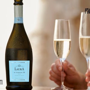 May include: A dark glass bottle of sparkling wine with a light blue label that reads "Laura is turning 30". Two champagne flutes are filled with wine. The PickUpWine.com logo is in the bottom left corner.