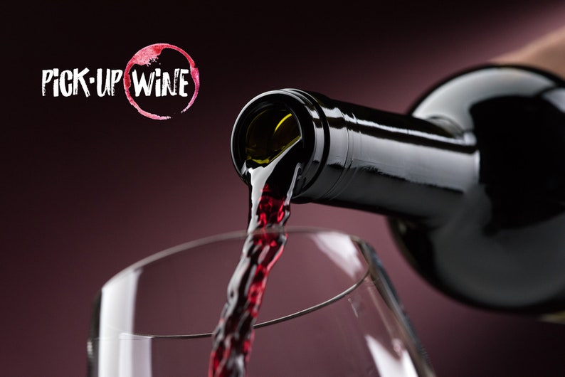 May include: A bottle of red wine being poured into a clear glass. The wine is a deep red color and the glass is clear. The text "PICK-UP WINE" is visible in the background.