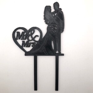 Pu&ograve; includere: Topper per torta in silhouette nera con una sposa e uno sposo con un cuore che dice "Mr & Mrs".