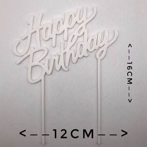 May include: White plastic cake topper with the words "Happy Birthday" in a cursive font. The topper is 12 inches wide and 16 inches tall.
